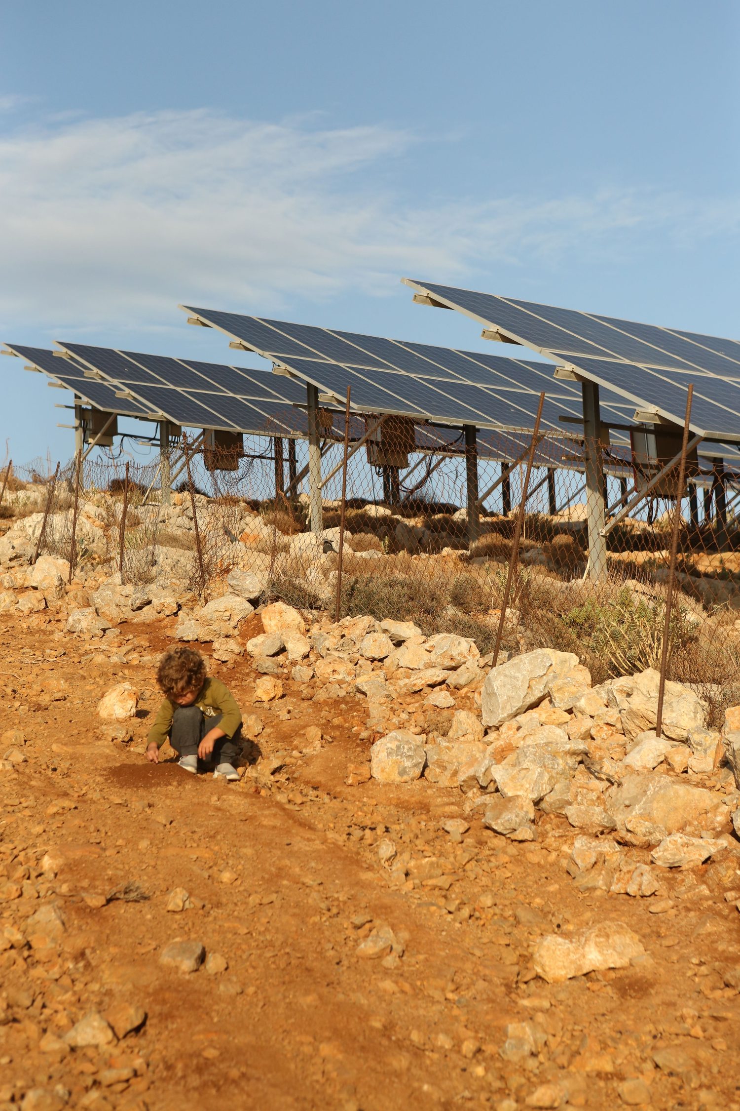 A child beside a hillside solar array